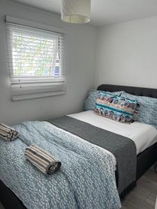a bed in a bedroom with a window and a bedskirtspectspectspectspects at Leysdown Beach Escape in Sheerness