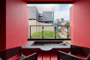 a room with a window with a table and two chairs at Calle Flora Hotel by Jalo in Medellín