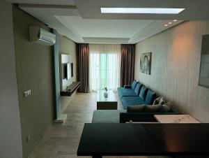 a living room with blue couches and a television at Residence Touristique La Rambla in Fnidek