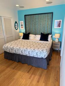a large bed in a bedroom with blue walls at Malibu Private Beach Apartments in Malibu