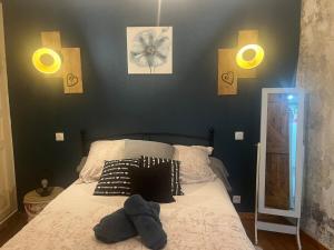 a bedroom with a bed with three lights on the wall at Maison de bourg avec Patio in Saint-Germain-Lembron