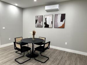 a dining room with a table and chairs and paintings at Spacious Modern 1 Bedroom RARE Apt w GYM in Albany