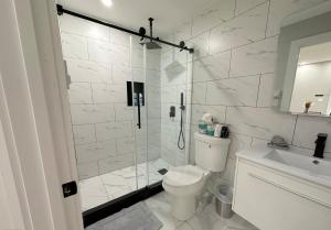 a bathroom with a shower and a toilet and a sink at Spacious Modern 1 Bedroom RARE Apt w GYM in Albany