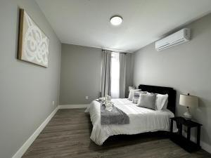 a bedroom with a bed with white sheets and a window at Spacious Modern 1 Bedroom RARE Apt w GYM in Albany
