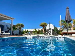 a swimming pool with blue water in a resort at Villa Queen Papagayo Vetusta in Playa Blanca