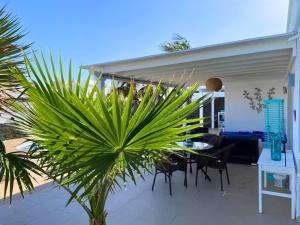 a patio with a table and chairs and a palm tree at Villa Queen Papagayo Vetusta in Playa Blanca