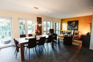 a dining room and living room with a table and chairs at Talblick 5, mit Sauna und wunderschönen Panoramablick NEU in Walkenried