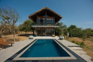 a house with a swimming pool in front of a house at The Yala Lodge in Kirinda