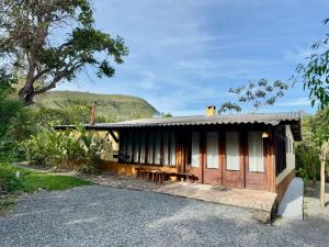 a cabin with a table and benches in front of it at Pousada Loquinhas in Alto Paraíso de Goiás
