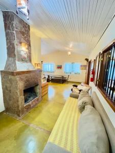 a living room with a large stone fireplace at Pousada Loquinhas in Alto Paraíso de Goiás