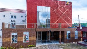 a red brick building with a balcony on it at H3 Hotel and Events Centre in Abeokuta