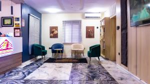Una sala de espera con tres sillas y un pasillo. en H3 Hotel and Events Centre, en Abeokuta