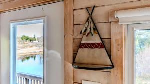 a hanging wall decoration on a wall next to a window at Georgian Bay Lakeview Cottage - Rockwood #5 in Dillon