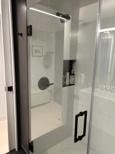 una ducha con puerta de cristal en un baño en Serif, en San Francisco 23 fotos más