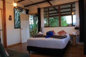 a bedroom with a bed in a room with windows at eco hotel finca los naranjos in Salento