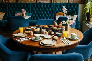 a table with food on it with blue chairs at Hotel 1635 in Haarlem