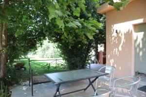 a table and chairs on a patio under a tree at Villa Theopetra in Theópetra