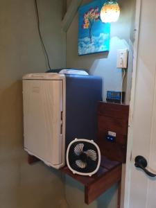 a room with a refrigerator and a fan on a table at Velamparas guest house in Barrancas