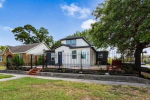 a small white house with a black fence at Gated 2BR Near Med Center NRG MD Anderson DT in Houston