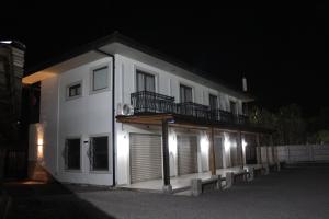 a white building with a balcony at night at Don'Ato Aparthotel in Santa Cruz