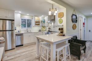 a kitchen with white cabinets and a white island at Hot Tub and Fenced Yard Cozy Cottage Grove Home in Cottage Grove