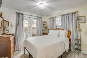 a bedroom with a white bed and a window at Hot Tub and Fenced Yard Cozy Cottage Grove Home in Cottage Grove