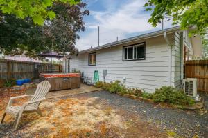 a white house with a chair and a hot tub at Hot Tub and Fenced Yard Cozy Cottage Grove Home in Cottage Grove +16 photos