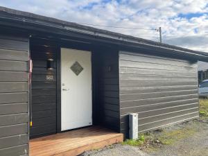 eine Garage mit einem weißen Tor und einer Holzveranda in der Unterkunft Wake up to the silence and beauty of the Lyngen Alps in Indre Tomasjord + 8 Fotos