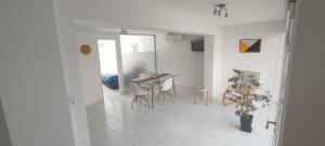 a white living room with a table and chairs at Departamento Moderno in Neuquén
