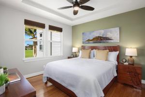 a bedroom with a bed and a ceiling fan at Poipu Retreat with Golf Ocean Views and AC in Koloa