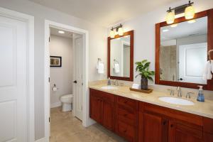 a bathroom with two sinks and a toilet at Poipu Retreat with Golf Ocean Views and AC in Koloa +37 photos