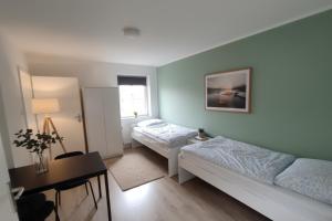 une petite chambre avec deux lits et une fenêtre dans l'établissement L21-Apartment Geilenkirchen OT Teveren, 3 Zimmer, 6 Betten, Standardisierte Ausstattung, ideal für Reisende, Pendler, Familien, à Geilenkirchen
