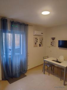 a room with a table and a window with a blue curtain at Le casette di Elia e Alice in Palermo