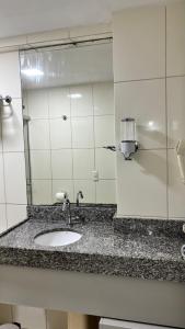a bathroom counter with a sink and a mirror at Blue Sunset Family Experience in João Pessoa