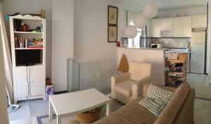 ein Wohnzimmer mit einer Couch und einem Tisch in der Unterkunft Apartamento Playa Muralla in El Puerto de Santa María + 13 Fotos
