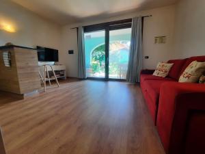a living room with a red couch and a large window at Porto Antigo 2 Beach Club 18 in Santa Maria