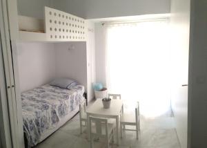 ein Schlafzimmer mit einem Bett und einem Tisch mit Stühlen in der Unterkunft Apartamento Playa Muralla in El Puerto de Santa María