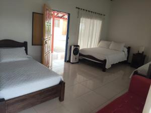 a bedroom with two beds and a tv in it at Finca Hotel la Manuela in Armenia