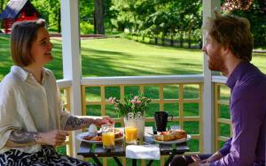 a man and a woman sitting at a table with breakfast at KAL791-Vimmerby-Fredensborg-120 in Storebro