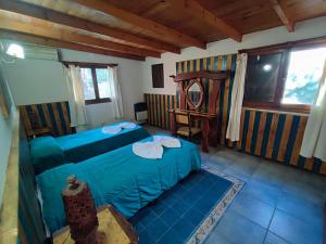 ein Schlafzimmer mit einem blauen Bett und einem Stuhl in der Unterkunft Casa del arroyo in Villa General Belgrano + 43 Fotos