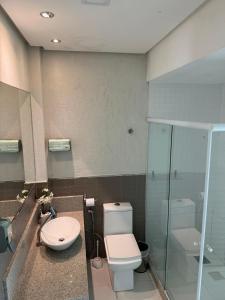 a bathroom with a toilet and a glass shower at Casa Da Enseada Azul com 5 SUITES - GUARAPARI in Guarapari +14 photos