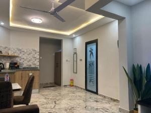 a living room with a ceiling fan and a kitchen at OB DELUXE Apartments 2 in Accra +8 photos