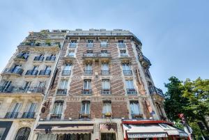 un edificio alto con un autobús delante de él en Villa Montparnasse, en París