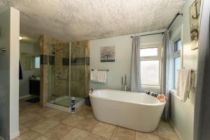 a large bathroom with a tub and a shower at A beautiful 2 bedroom private home in Hinton +48 photos