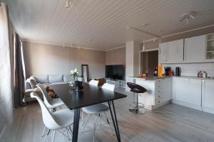 a kitchen and a living room with a table and chairs at Arctic Apartment Heart of Tromsø in Tromsø