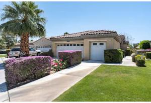 a house with a palm tree and a garage at Lakefront 3BR Indio Retreat with Backyard and Games in Indio
