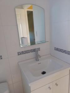 a white bathroom with a sink and a mirror at Cabaña Vista Hermosa in Traitraico
