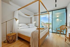 a bedroom with a canopy bed and a balcony at Luxury 5-Star Stay at Savoy Insular in Funchal