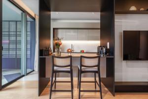 a kitchen with two bar stools and a counter at Luxury 5-Star Stay at Savoy Insular in Funchal