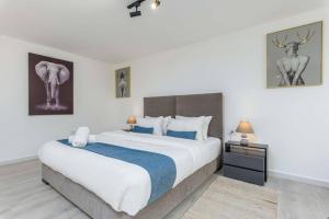 a bedroom with a large bed with a blue blanket at Indigo - Duplex 1-BR Apt with Terrace & Garden in Batroun in Al Ḩulwah